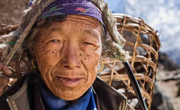 Nepalese woman carrying basket in mountains